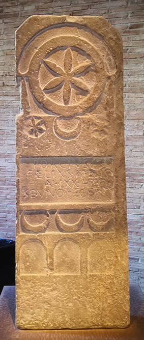 Estela funeraria romana del Museo de Navarra con una flor hexapétala